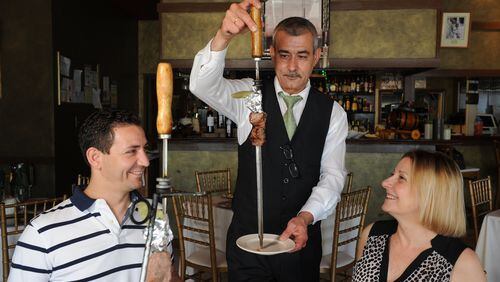 Waiter Jorge Silva serves regular customers Regina and Carlos Mendes at Emidio's in Sandy Springs. (Beckysteinphotography.com)