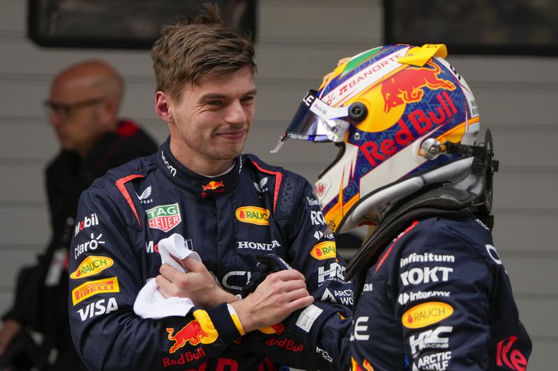Red Bull driver Max Verstappen, left, of the Netherlands is congratulated by teammate Sergio Perez of Mexico after taking pole position following qualifying at the Chinese Formula One Grand Prix at the Shanghai International Circuit, Shanghai, China, Saturday, April 20, 2024. Perez qualified second fastest. (AP Photo/Andy Wong)