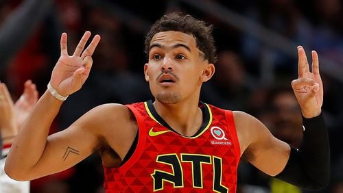 Hawks guard Trae Young signals a three-point shot during a foul in the second half Nov. 5, 2019, against the San Antonio Spurs at State Farm Arena in Atlanta.