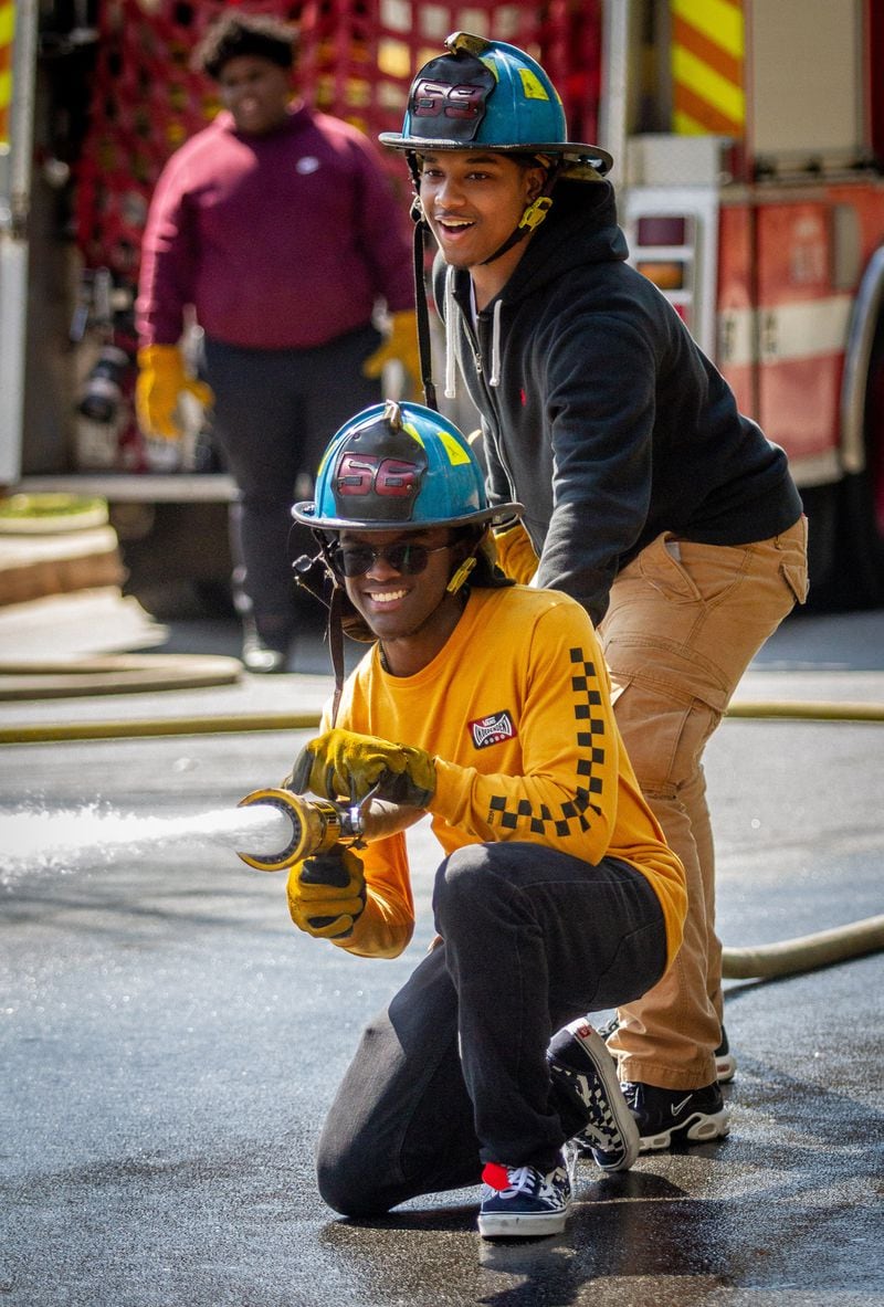 Therrell High School senior DeiAndre Penny and Marquis Lowe participate in the Atlanta Fire departments Delayed Entry Program training at there high school Thursday, March 21, 2019.  STEVE SCHAEFER / SPECIAL TO THE AJC