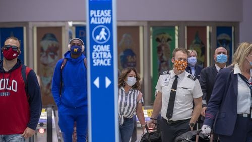 Masked airline passengers arrive at Hartsfield Jackson International Airport on May 20, 2020. (ALYSSA POINTER / ALYSSA.POINTER@AJC.COM)