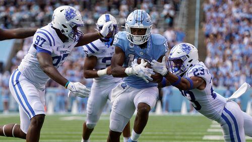 North Carolina running back Ty Chandler (19) runs while Duke defensive end Caleb Oppan (97) and Duke safety Lummie Young IV (23) reach to tackle during the second half Saturday, Oct. 2, 2021, in Chapel Hill, N.C. (Gerry Broome/AP)