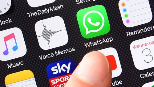 A persons finger is posed next to the Whatsapp app logo on an iPhone on August 3, 2016 in London, England.