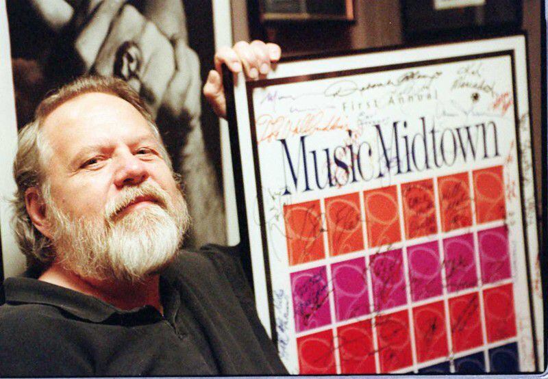 The late Alex Cooley poses with a poster from the first Music Midtown in 1994. Photo: Charlotte B. Teagle/AJC