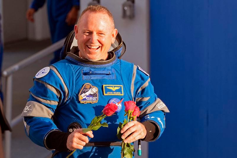 NASA astronaut Butch Wilmore carries roses to hand out to relatives as he leaves the Operations and Checkout building before heading to Space Launch Complex 41 to board the Boeing's Starliner capsule atop an Atlas V rocket for a mission to the International Space Station at the Cape Canaveral Space Force Station Monday, May 6, 2024, in Cape Canaveral, Fla. (AP Photo/John Raoux)