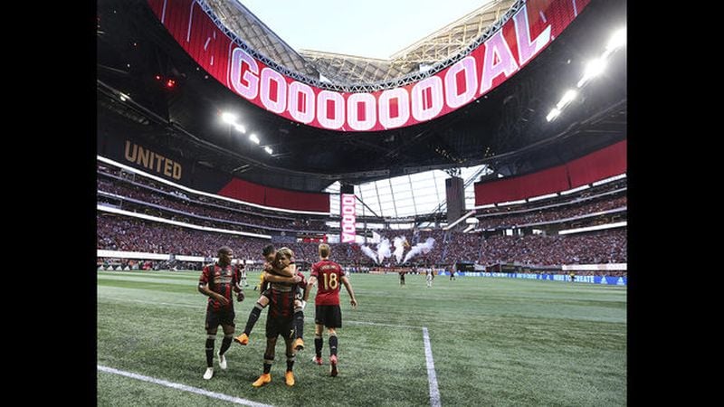 In this June 2, 2018, file photo, the roof of Mercedes-Benz Stadium is open as Atlanta United forward Josef Martinez celebrates his goal against the Philadelphia Union on a penalty kick while Miguel Almiron jumps on his back during an MLS soccer match in Atlanta. The 2026 World Cup will return to the U.S. for the first time since 1994. Atlanta's new Mercedes-Benz Stadium was shown prominently in the video used in the North American pitch for the bid. (Curtis Compton/Atlanta Journal-Constitution)