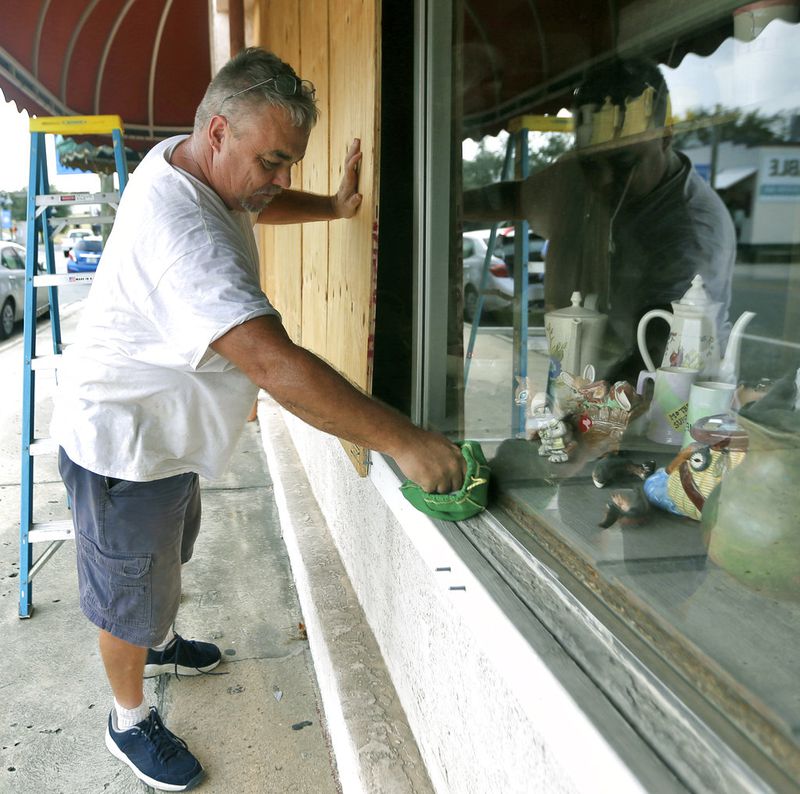 Bobby Smith boards up the windows at Jani's Ceramics in Panama City, Fla., on Monday, Oct. 8, 2018, in preparation for the arrival of Hurricane Michael. (Patti Blake/News Herald via AP)