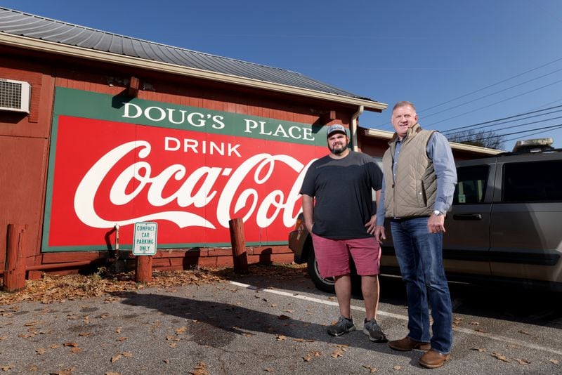 Doug’s Place owner Mark Sullins, right, is shown with Aaron Ferguson outside at the Doug’s Place sign on Old Allatoona Road, Thursday, November 3, 2022, in Emerson, Ga. Aaron is the son of founder Doug Ferguson. (Jason Getz / Jason.Getz@ajc.com)