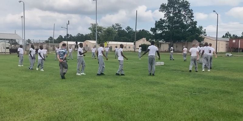 Cadets with the Fort Gordon Youth Challenge Academy's summer 2022 session exercise on the grounds of the Army post outside Augusta in this image from a video posted to the academy's Facebook page. Meanwhile, an instructor in a camouflage shirt barks out commands to the group. The October brawls at the Fort Gordon academy involved a different group of students in a later session that began in the fall. (Facebook)