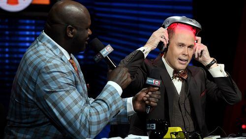 LAS VEGAS, NV - JANUARY 05:  NBA analyst Shaquille O'Neal (L) looks on as TNT's Inside the NBA host Ernie Johnson Jr. puts on an iGrow laser-based hair-growth helmet during a live telecast of "NBA on TNT" at CES 2017 at the Sands Expo and Convention Center on January 5, 2017 in Las Vegas, Nevada. CES, the world's largest annual consumer technology trade show, runs through January 8 and features 3,800 exhibitors showing off their latest products and services to more than 165,000 attendees.  (Photo by Ethan Miller/Getty Images)