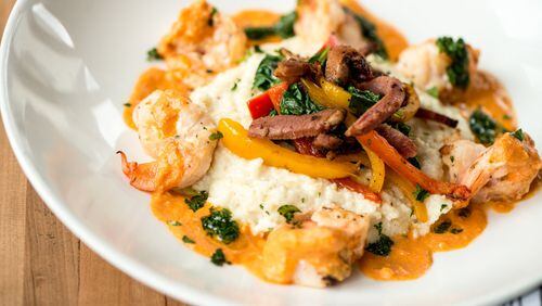 Camps Kitchen & Bar shrimp and grits with creamy cheese grits, spinach, tasso ham, bell peppers, and smoked tomato cream. Photo credit- Mia Yakel.