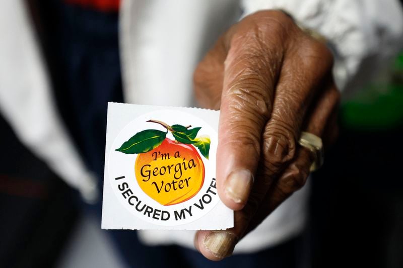 A poll worker holds a Georgia voter sticker at Berean Christian Church on Oct. 17, 2022. (Miguel Martinez/The Atlanta Journal-Constitution/TNS)