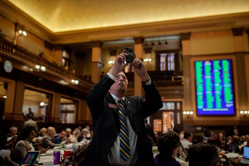 Rep. Tommy Benton takes a photo of voting results on Sine Die, the last day of the General Assembly at the Georgia State Capitol in Atlanta on Monday, April 4, 2022.   Branden Camp/ For The Atlanta Journal-Constitution