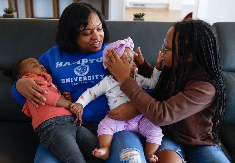 Precious Andrews sits with her daughters Bella, 2 (left), nine month old Ryleigh (center), and 12 year old Laila (right) during her lunch break on Friday, February 10, 2023. (Natrice Miller/ Natrice.miller@ajc.com)