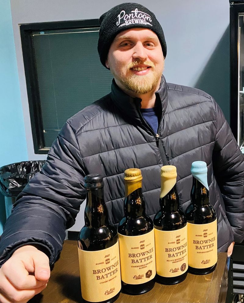 Pontoon Brewing co-owner Sean O’Keefe displays a selection of barrel-aged Brownie Batter beers. Bob Townsend for The Atlanta Journal-Constitution
