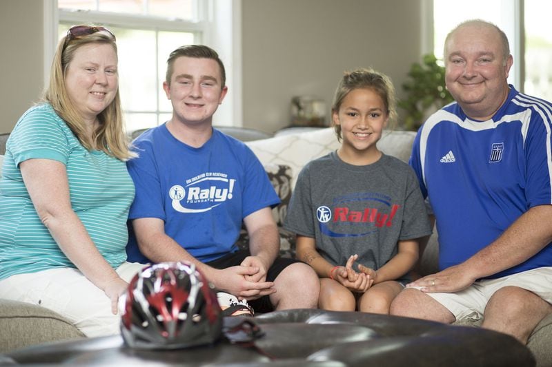 Matthew McMahon (second from left), who has fought cancer, sits in the family living room in Woodstock with (from left) his mother, Kerri, his sister, Madison, and his father, Chris. “He never once said ‘why me?’” Kerri McMahon said. “He just took it head on. He’s had bad days, but his main focus has always been getting back out there with his friends and playing sports again.” CHAD RHYM / CHAD.RHYM@AJC.COM