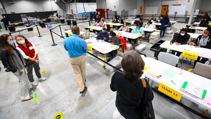 Observers both stand and walk around the perimeter of an area that votes for President are being recounted at the Gwinnett County elections office on Friday, Nov.13, 2020 in Lawrenceville. (JOHN AMIS FOR THE ATLANTA JOURNAL-CONSTITUTION)