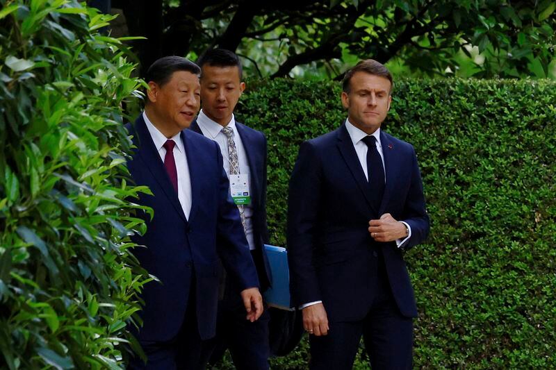 China's President Xi Jinping, left, and French President Emmanuel Macron walk in garden of the Elysee Palace after a joint statement, Monday, May 6, 2024 in Paris. French President Emmanuel Macron put trade disputes and Ukraine-related diplomatic efforts on top of the agenda for talks Monday with Chinese President Xi Jinping, who arrived in France for a two-day state visit opening his European tour. (Sarah Meyssonnier/Pool via AP)