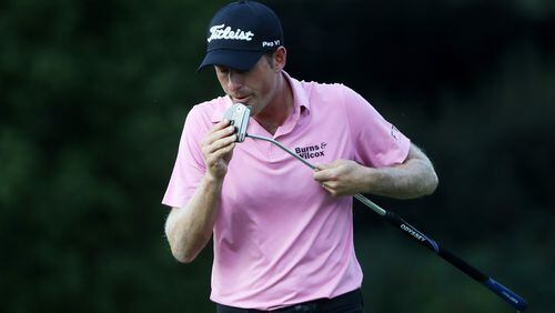 Tour Championship co-leader  Webb Simpson gives his putter a good talking to on East Lake’s 16th green Friday.  (Sam Greenwood/Getty Images)