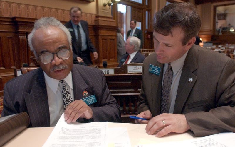 Reps. Tyrone Brooks Sr. (D-Atlanta), left, and Mike Coan (R-Lawrenceville) take time following the Jan. 26, 2005, Legislative session to go over a package of bills to remove Jim Crow-era segregation laws from Georgia code. 
