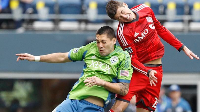 Seattle Sounders FC midfielder Clint Dempsey (2) and Toronto FC defender Mark Bloom (28) jump for a header during the first half at CenturyLink Field. Joe Nicholson-USA TODAY Sports