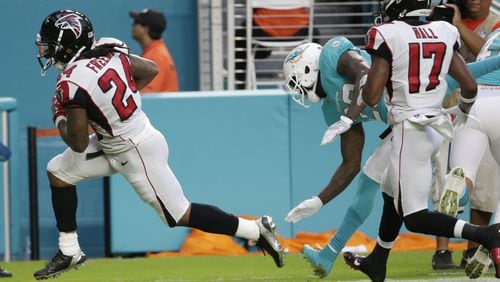 Atlanta Falcons running back Devonta Freeman (24) scores a touchdown ahead of Miami Dolphins free safety Reshad Jones (20), during the first half of an NFL preseason football game, Thursday, Aug. 10, 2017, in Miami Gardens, Fla. Atlanta Falcons wide receiver Marvin Hall (17) is at right. (AP Photo/Lynne Sladky)