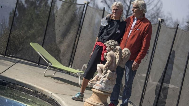 The Pascoes stand near a statue of an angel overlooking their neighbor’s pool, one of the few objects that survived the raging inferno that destroyed the couple’s Santa Rosa, Calif., neighborhood. The spent six hours in the pool, but survived the flames.
