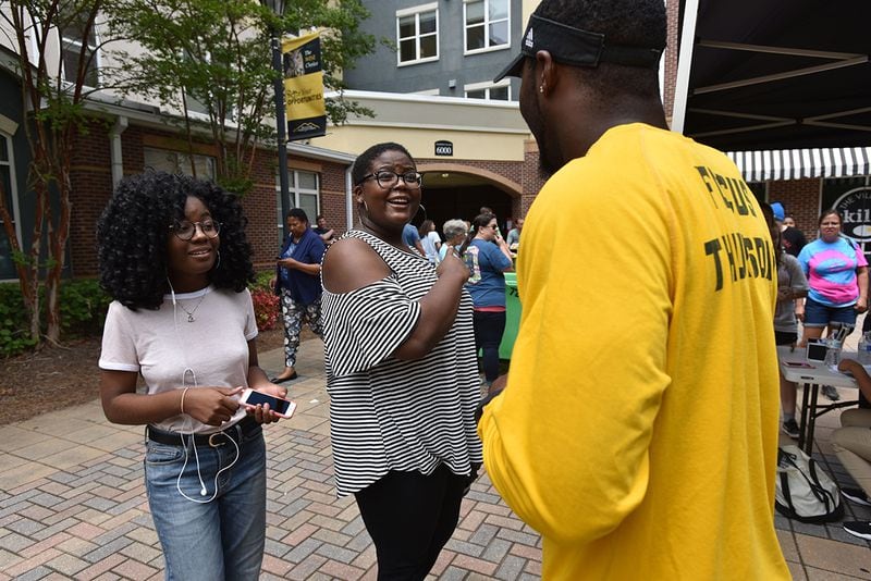 Delanie Mason and her sister Deja Mason, left, talk with a KSU football player during Kennesaw State University Housing Move-In day on Friday, August 11, 2017. (HYOSUB SHIN / HSHIN@AJC.COM)