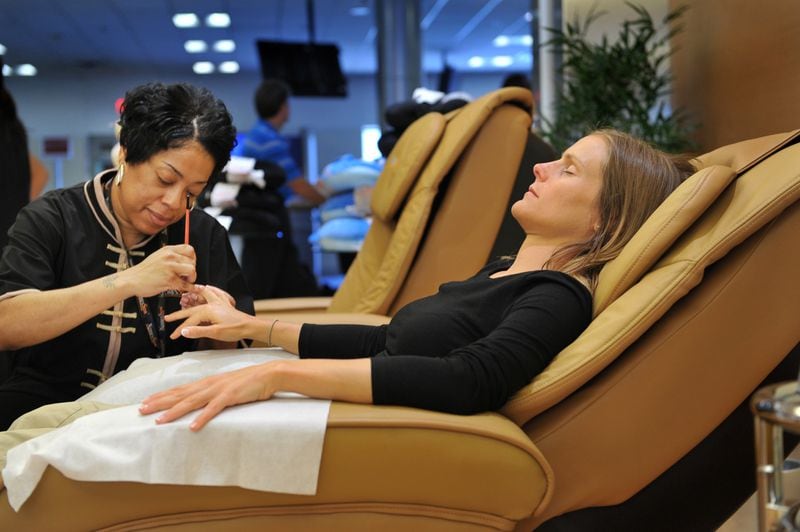 An XpresSpa employee does the nails of a traveler at Hartsfield-Jackson. RICH ADDICKS / AJC
