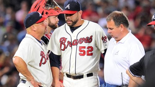 Atlanta Braves manager Fredi Gonzalez (33) removes relief pitcher Jordan Walden (52) from the game after Walden is hit by a line drive off his pitching hand against the Miami Marlins during the ninth inning at Turner Field on Aug. 10, 2013. The Marlins defeated the Braves 1-0.