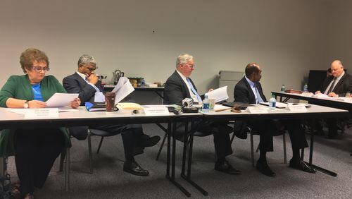 Gwinnett County Ethics Board members (from left) Teri Duncan, Charles Rousseau, David Will and Herman Pennamon listen Tuesday as board attorney Read Gignilliat speaks. TYLER ESTEP / TYLER.ESTEP@AJC.COM