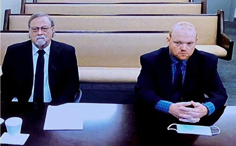 In this image made from video, father and son, Gregory and Travis McMichael, from left, accused in the shooting death of Ahmaud Arbery in Georgia, listen via closed circuit TV in the Glynn County detention center in Brunswick on Thursday, Nov. 12, 2020, as lawyers argue for bond to be set at the Glynn County courthouse. (AP Photo/Lewis Levine)
