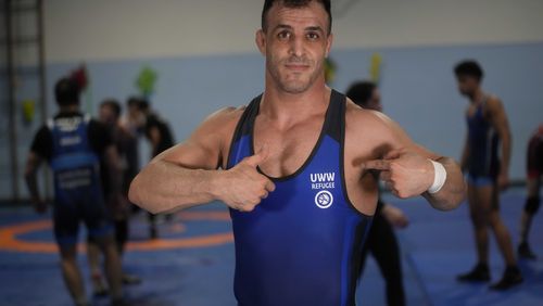 Iranian wrestler Iman Mahdavi, 28, a member of the Refugee Team for the Paris Olympics, poses at the Lotta Club Seggiano gym, in Pioltello, near Milan, Italy, Wednesday, Feb. 28, 2024. The Refugee Team for the Paris Olympics will feature 36 athletes from 11 countries in 12 sports. International Olympic Committee president Thomas Bach says the team was selected from more than 70 scholarships. Instead of competing under the Olympic flag, the refugees will have their own emblem featuring a heart at its center surrounded by arrows. (AP Photo/Luca Bruno)