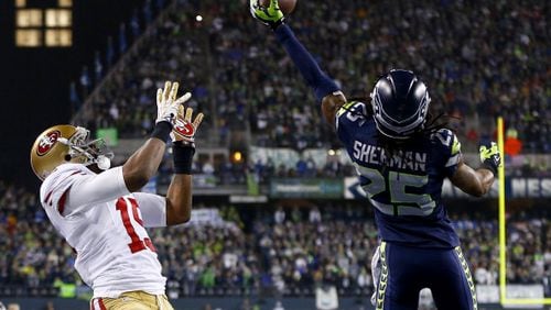 SEATTLE, WA - JANUARY 19:  Cornerback Richard Sherman #25 of the Seattle Seahawks tips the ball up in the air as outside linebacker Malcolm Smith #53 catches it to clinch the victory for the Seahawks against the San Francisco 49ers during the 2014 NFC Championship at CenturyLink Field on January 19, 2014 in Seattle, Washington.  (Photo by Jonathan Ferrey/Getty Images)