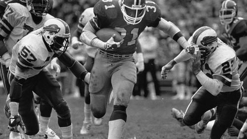 William Andrews pushes through a hole against the Buffalo Bills in 1984 (Louie Favorite/AJC staff)