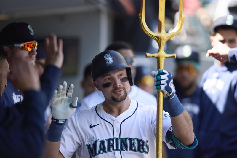 Seattle Mariners catcher Cal Raleigh celebrates in the dugout after hitting a solo home run during the second inning of a baseball game against the Cincinnati Reds, Wednesday, April 17, 2024, in Seattle. (AP Photo/John Froschauer)