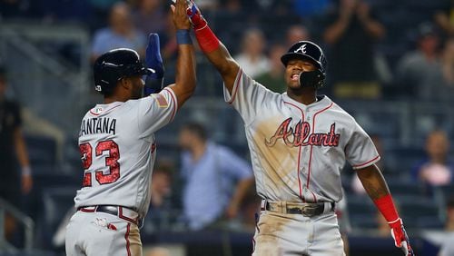 Ronald Acuna celebrates with Danny Santana after hitting a two-run homer in the 11th inning of Monday's 5-3 win over the Yankees in New York.