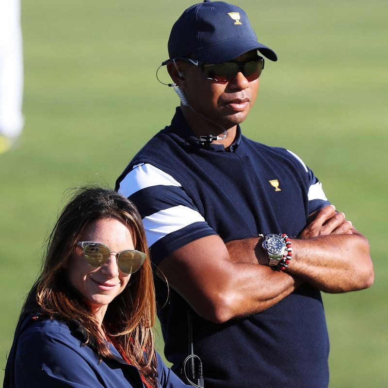 Captain's assistant Tiger Woods of the U.S. Team and Erica Herman look on during Sunday singles matches of the Presidents Cup Oct. 1, 2017, at Liberty National Golf Club on  in Jersey City, N.J.