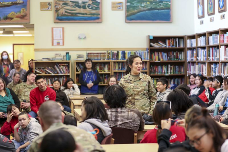 In this image provided by the Alaska Air National Guard, Alaska Air National Guard Staff Sgt. Sharon Queenie with the 176th Air Defense Squadron speaks to students from her hometown of St. Mary's, Alaska, during a recruiting initiative at Andreafski High School, March 31, 2023. Queenie is one of several guard members slated to have their personnel status changed to technician status, which will cut her pay by about 50%. (Balinda O'Neal/Alaska Air National Guard via AP)