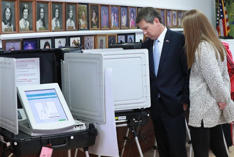 Then-Secretary of State Brian Kemp, the Republican candidate for Georgia governor, with his daughter Amy Porter, casts his vote at the Winterville Train Depot on Nov. 6. He initially had a problem voting because his yellow voter access card didn’t work. Curtis Compton/ccompton@ajc.com