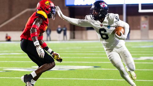 Valdosta State wide receiver Lio'undre Gallimore (6) stiff arms Ferris State defensive back Alex Thomas (0) in the first half of the Division II championship NCAA college football game against Ferris State in McKinney, Texas, Saturday, Dec. 18, 2021. (AP Photo/Emil Lippe)