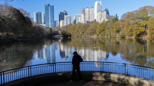 December 21, 2016 Atlanta: Mason Voudrie took in the view of the midtown Atlanta skyline reflected in Lake Clare Meer at Piedmont Park on the first day of winter, Wednesday, Dec. 21, 2016. Winter officially began with cold morning temperatures leaving a thin layer of frost that covered some lawns, mailboxes and cars. But as the day progressed it didn't seem so wintry, "But sunshine's out this afternoon, pushing our high today into the upper 50s and a few low-to-mid 60s,"? Channel 2 meteorologist Karen Minton said. It will get even warmer this weekend. Temps are expected to reach 57 degrees Christmas Eve and increase to 64 degrees Christmas Day. There is also a 30 percent chance of rain Saturday and a 20 percent rain chance Sunday. JOHN SPINK /JSPINK@AJC.COM