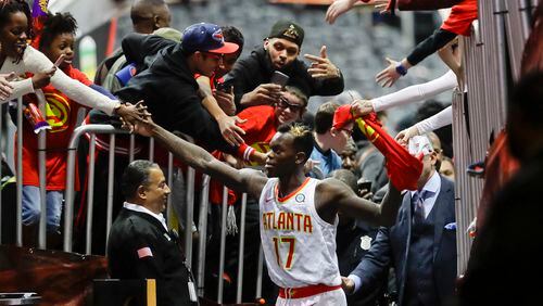 Atlanta Hawks guard Dennis Schroder (17) is mobbed by fans as he leaves the court following their 102-99 win over the San Antonio Spurs in an NBA basketball game Monday, Jan. 15, 2018, in Atlanta. (AP Photo/John Bazemore)