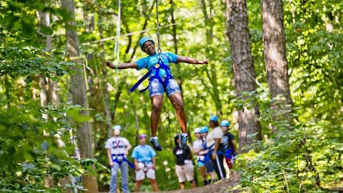 Noa Bennafield flies through the air on a zip line at Camp Timber Ridge in Mableton. The Girl Scout camp is one of 48 in Georgia accredited by the American Camp Association. JONATHAN PHILLIPS / SPECIAL