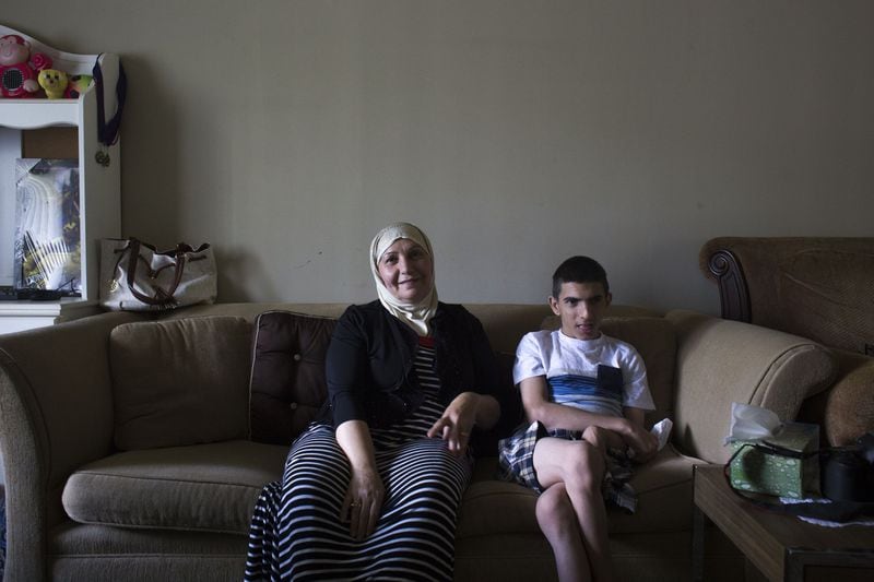 Family friend Saadia Mohamed Kelli sits with Alan Youssef at Alan’s home in Decatur. Alan fled Syria with his Kurdish family four years ago amid the civil war. Chad Rhym/ Chad.Rhym@ajc.com
