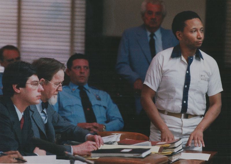 19860210 - JACKSON, GA - ウェイン-ウィリアムズはバッツ郡の高等裁判所の裁判官Hal Craigの前に立っています。 ウィリアムの弁護人 (l-r) Ron Kuby, Bobby Lee Cook, Jackson Diagnostic Center officer Neil Earnhart, baliff W.N. Johnson (standing background)です。 (STEVE DEAL/AJC staff) 1986