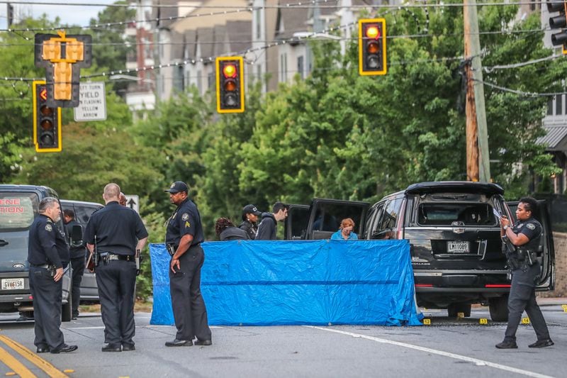 Atlanta police draped a blue tarp in front of a black Cadillac Escalade after a woman was killed Tuesday at the intersection of Lindbergh and Adina drives.