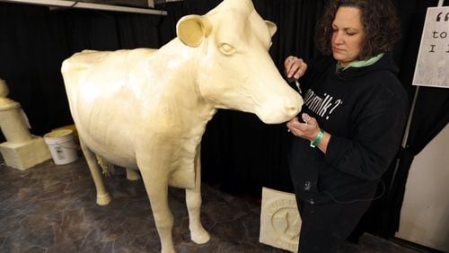 In this Thursday, Aug. 10, 2017, photo, sculptor Sarah Pratt works on the Butter Cow at the Iowa State Fair in Des Moines, Iowa. More than 1 million people typically visit the Iowa State Fair annually, and sometimes it seems like all of them are clustered around Butter Cow. The creamy creation has been among the state fair's top attraction since 1911. (AP Photo/Charlie Neibergall)