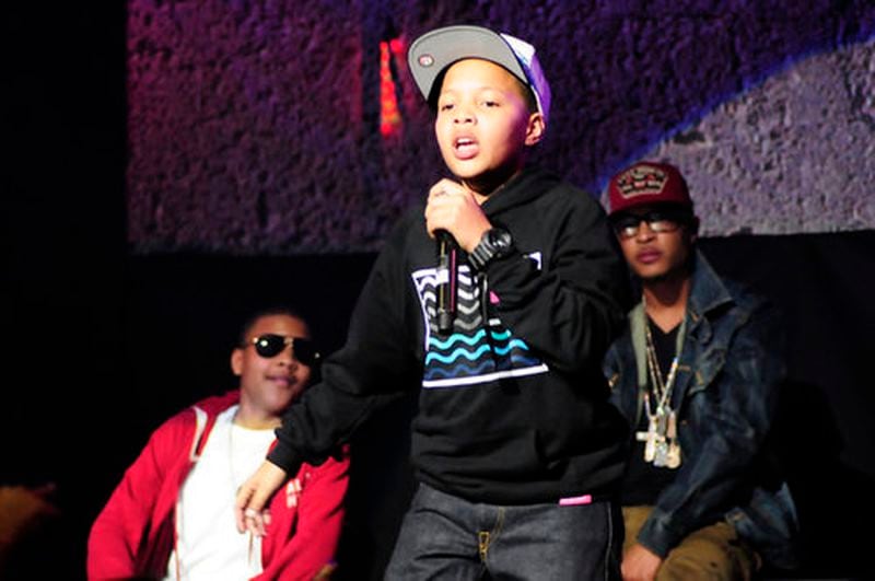 Domani performs while his father, T.I. (in the background) watches in 2012 at the Fox Theatre.
