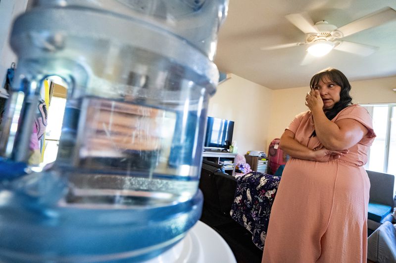 Richelle Dietz, a Navy spouse whose family was impacted by the fuel jet leak that tainted their water in 2021, wipes away tears as she discusses the toll of the trial at her home on Monday, April 22, 2024, in Honolulu, Hawaii. (AP Photo/Mengshin Lin)